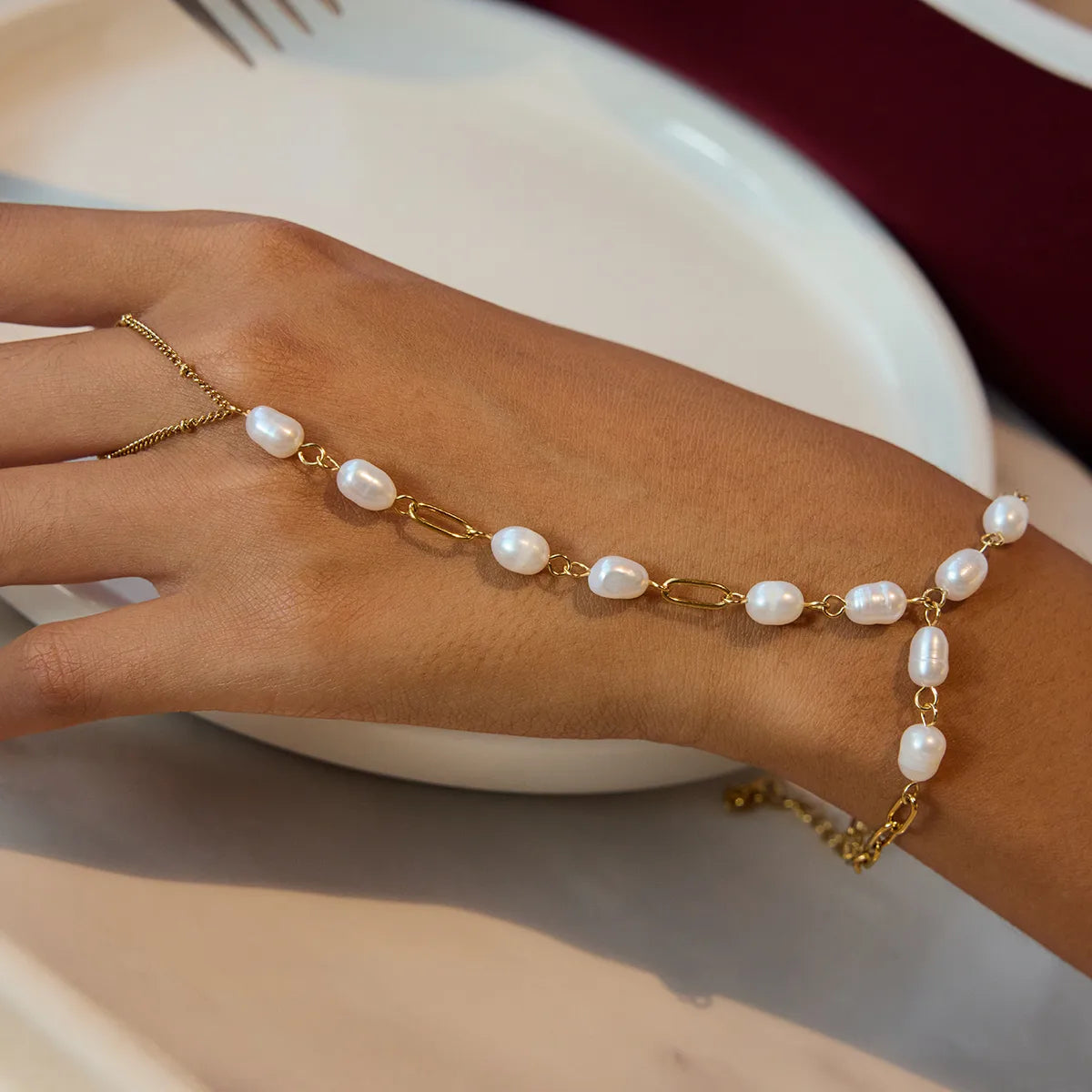 Pulsera Dorada con Perlas y Diseño de Mano